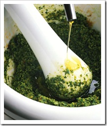 Making basil pesto the traditional way with a mortar and pestle